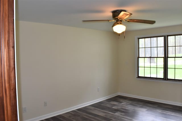 empty room with ceiling fan and dark hardwood / wood-style flooring