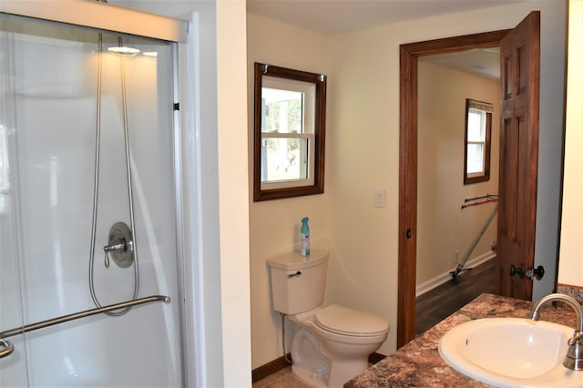 bathroom with toilet, a shower with door, and vanity