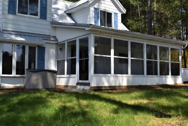 view of home's exterior with a yard and a sunroom