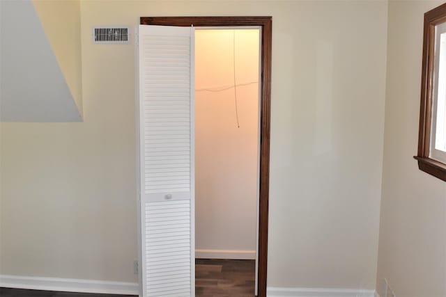 unfurnished bedroom featuring dark wood-type flooring, a closet, and a walk in closet