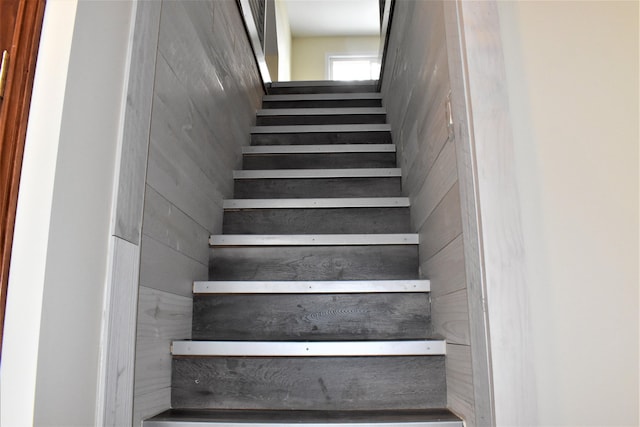 stairs featuring wooden walls