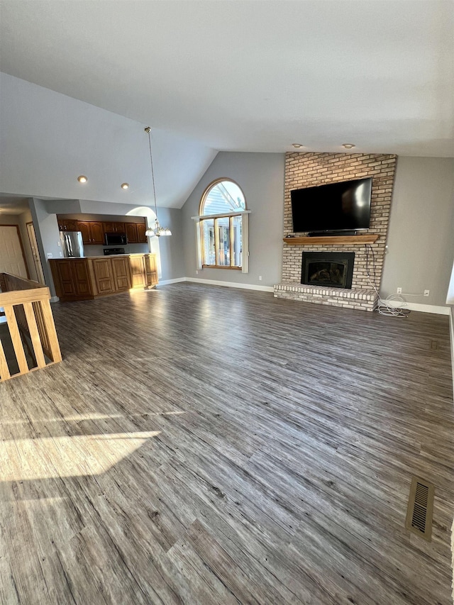 unfurnished living room with vaulted ceiling, a fireplace, and dark hardwood / wood-style flooring