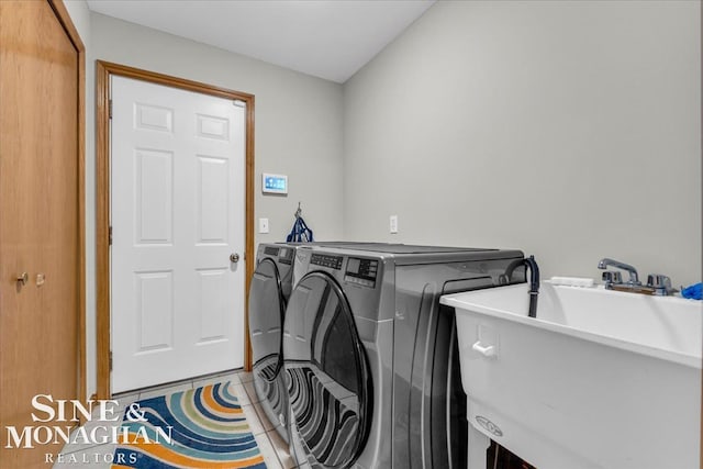 laundry area featuring washer and dryer, tile patterned flooring, and sink