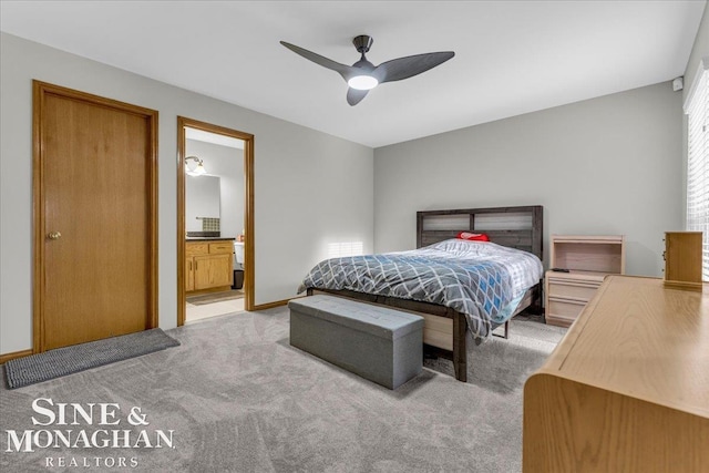 bedroom with ceiling fan, light colored carpet, and connected bathroom