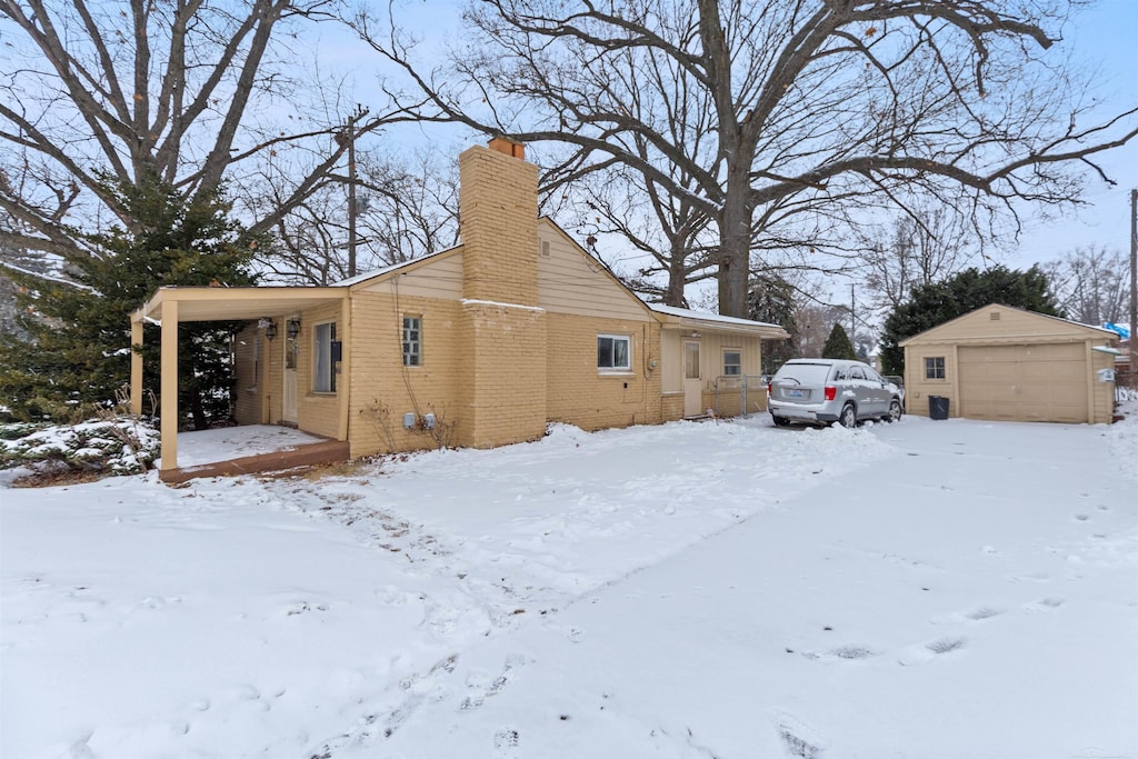 view of snow covered exterior with an outdoor structure and a garage