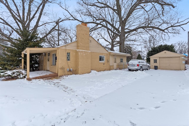 view of snow covered exterior with an outdoor structure and a garage