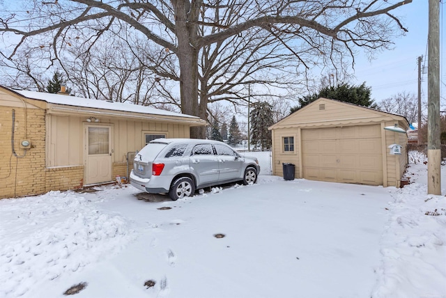 view of snow covered exterior with a garage and an outdoor structure