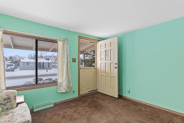 unfurnished room with dark colored carpet