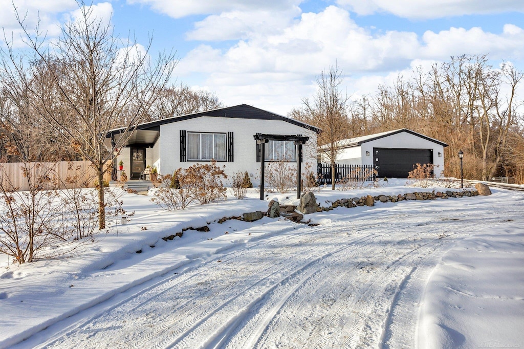 snow covered structure featuring a garage