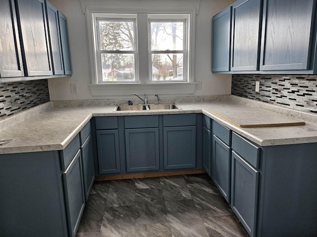 kitchen with blue cabinets, backsplash, and sink