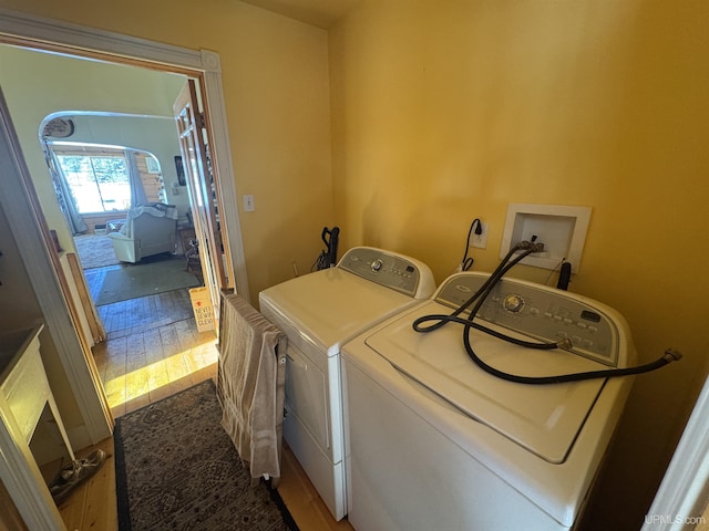 washroom with hardwood / wood-style flooring and washing machine and dryer