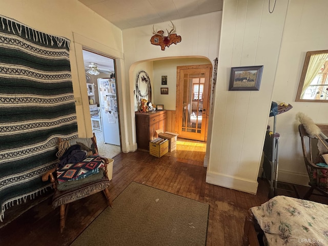 hallway with dark hardwood / wood-style flooring and wooden walls