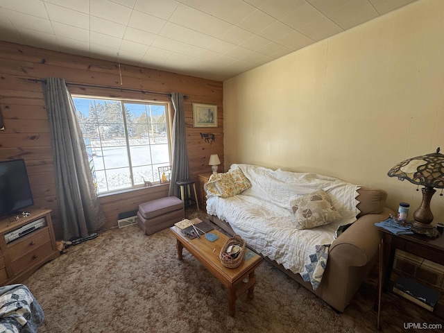 carpeted living room featuring wooden walls