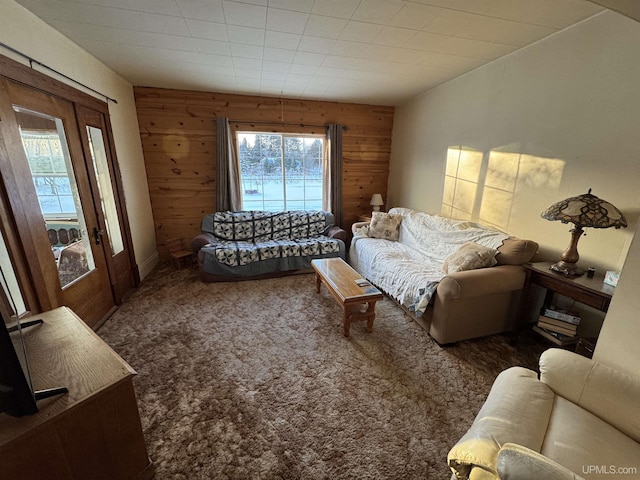 carpeted living room featuring wood walls