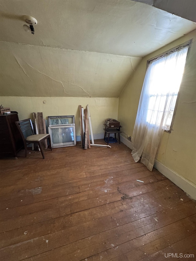 bonus room with dark hardwood / wood-style floors and vaulted ceiling