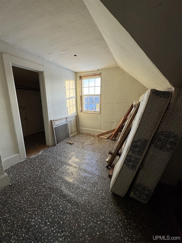 additional living space featuring vaulted ceiling and a textured ceiling