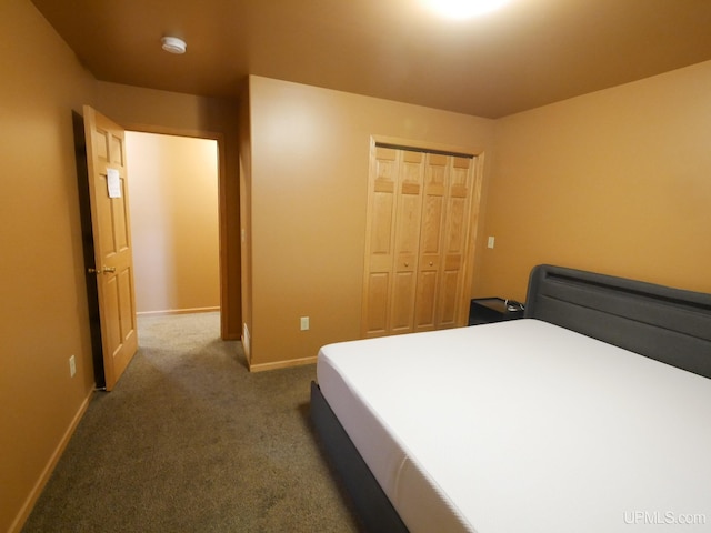 bedroom with dark carpet and a closet