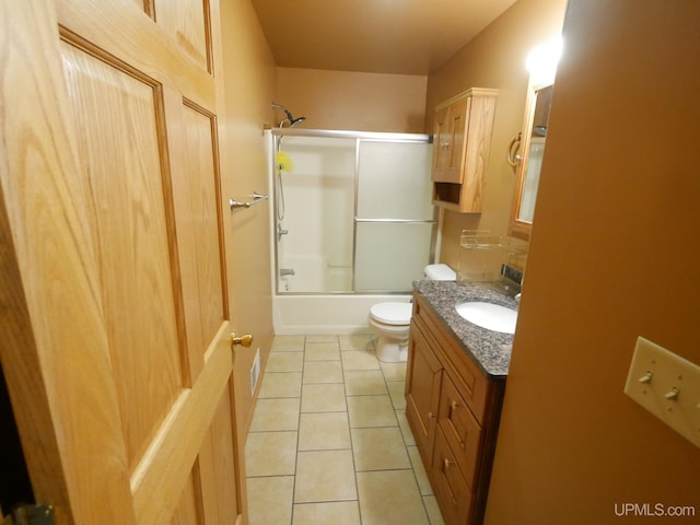 full bathroom featuring toilet, vanity, tile patterned flooring, and enclosed tub / shower combo