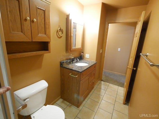 bathroom featuring toilet, vanity, and tile patterned flooring