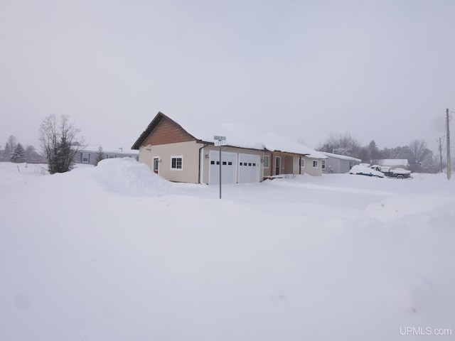 view of snowy exterior featuring a garage