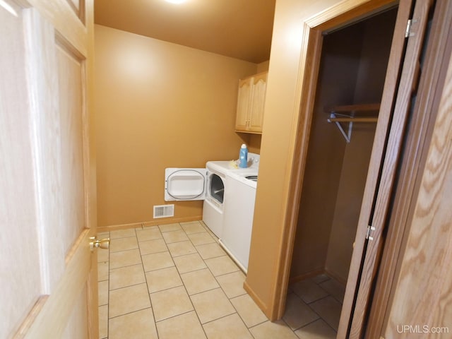 laundry room with cabinets, light tile patterned floors, and independent washer and dryer