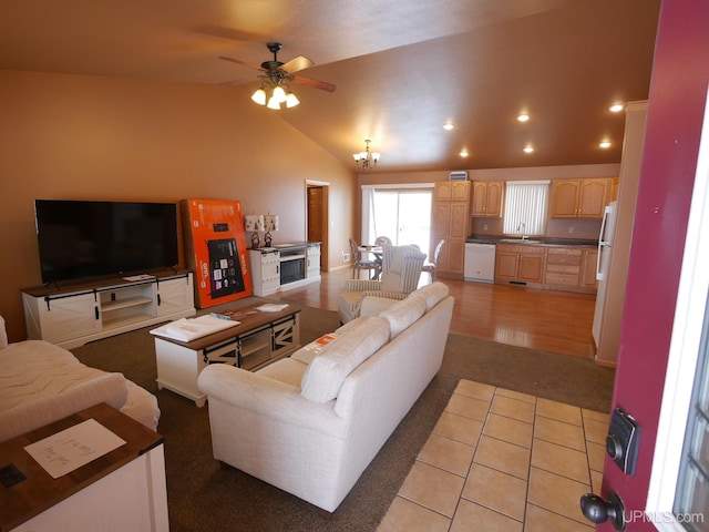 living room with lofted ceiling and ceiling fan with notable chandelier