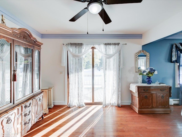 sitting room with ceiling fan, a baseboard radiator, and light hardwood / wood-style flooring