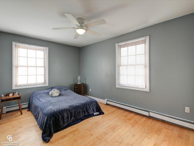 bedroom with baseboard heating, light hardwood / wood-style floors, and ceiling fan