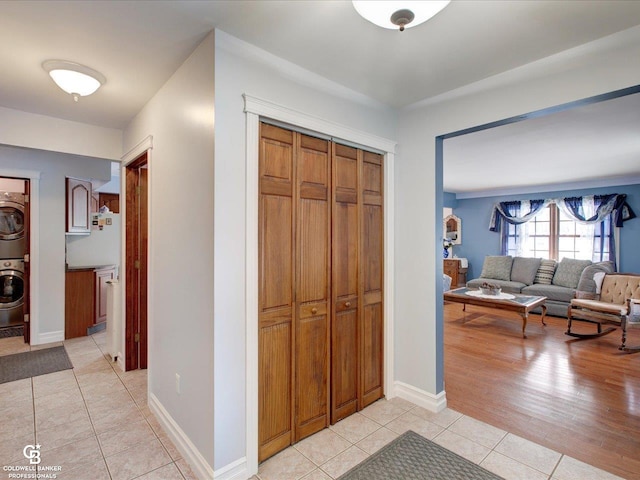 foyer with light tile patterned flooring and stacked washer / dryer