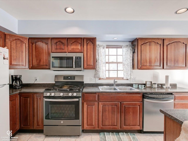 kitchen featuring light tile patterned floors, stainless steel appliances, and sink