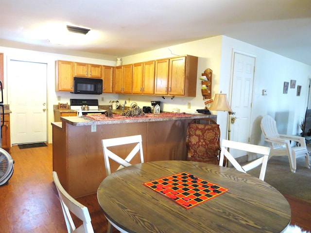 kitchen featuring kitchen peninsula, light hardwood / wood-style flooring, and range with electric cooktop