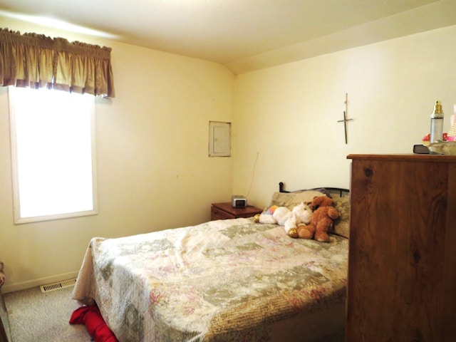 carpeted bedroom with electric panel and lofted ceiling