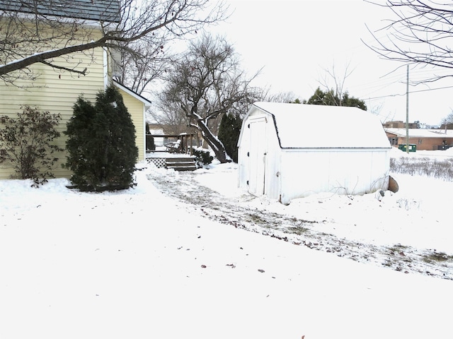 yard layered in snow with a storage unit