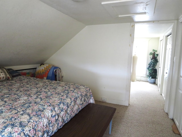 bedroom with lofted ceiling and light carpet