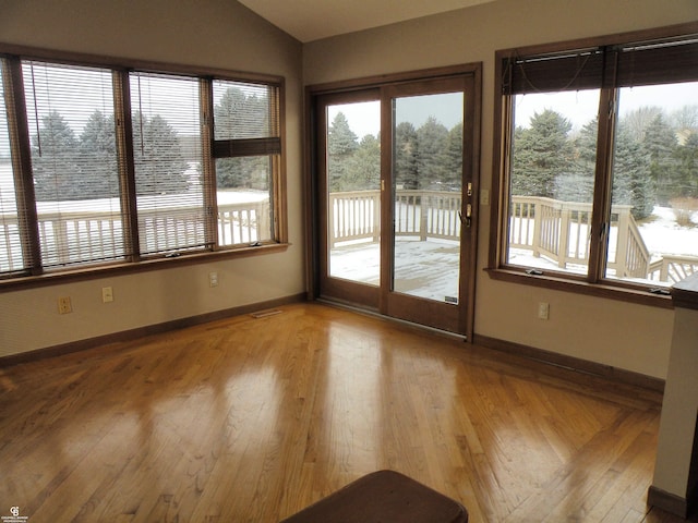 unfurnished sunroom featuring a water view and lofted ceiling