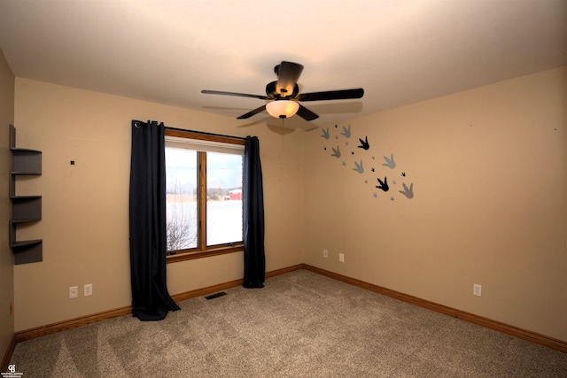 carpeted spare room featuring ceiling fan