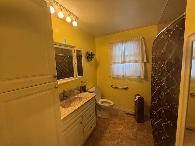 bathroom with toilet, a shower with shower curtain, and vanity