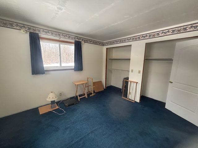 unfurnished bedroom featuring dark colored carpet