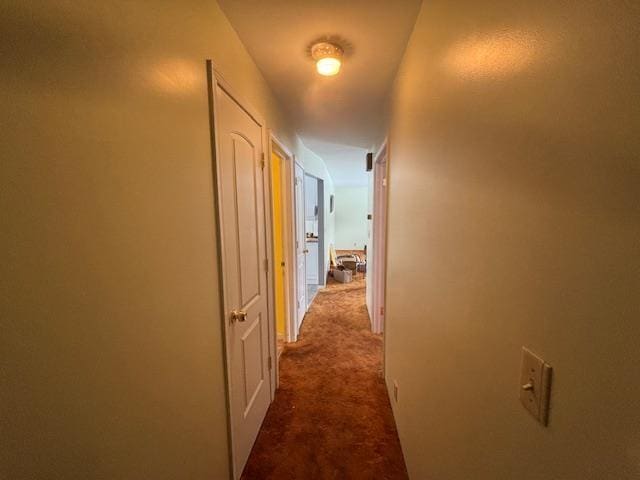 hall featuring dark carpet