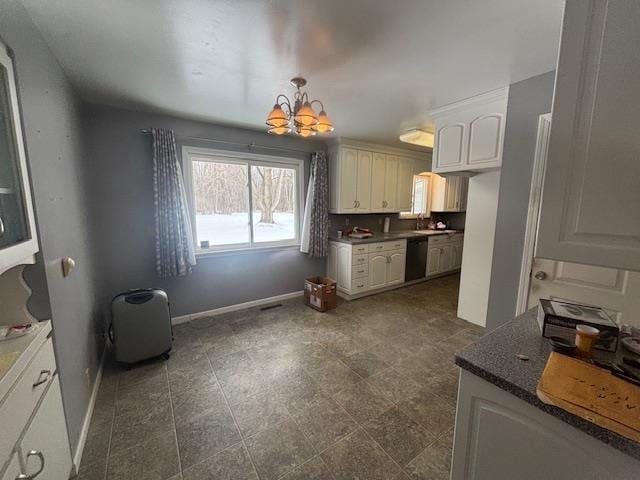 kitchen featuring decorative light fixtures, white cabinets, dishwasher, and a notable chandelier