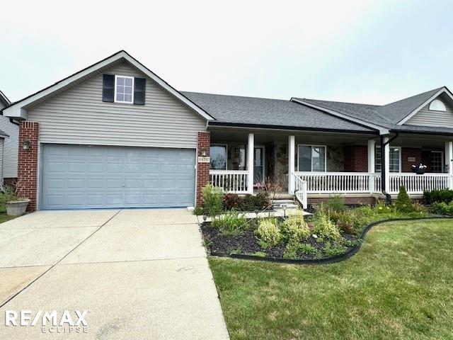 ranch-style house featuring a front lawn, a garage, and a porch