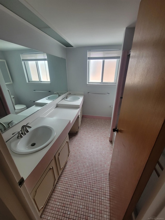 bathroom featuring vanity, plenty of natural light, and toilet