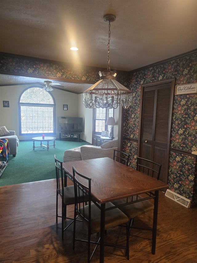 dining space with ceiling fan with notable chandelier