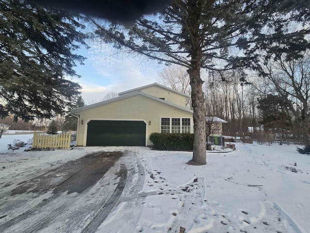 view of snow covered exterior featuring a garage