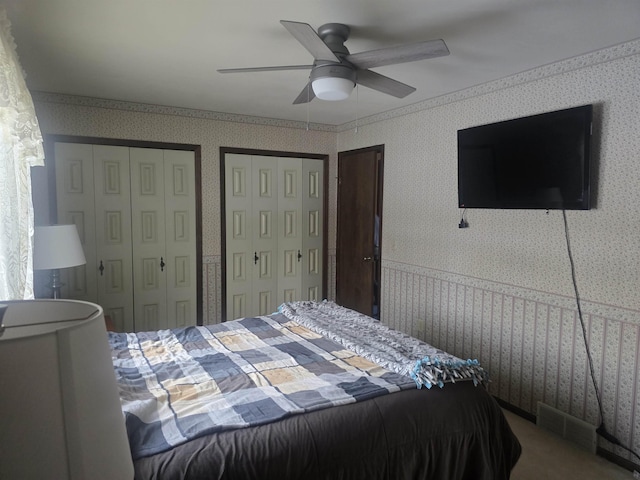 bedroom featuring ceiling fan and two closets