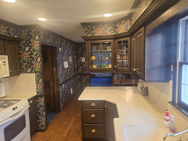 kitchen featuring sink, white appliances, and dark brown cabinetry