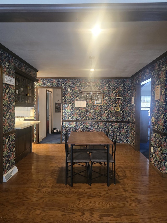 dining space featuring dark hardwood / wood-style floors and ornamental molding