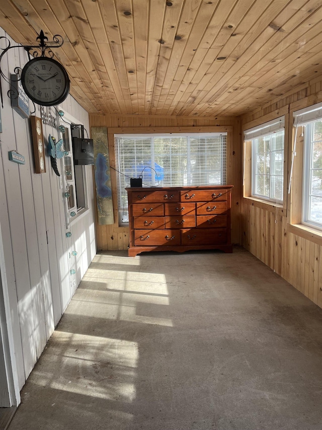 interior space featuring wooden walls, multiple windows, and wooden ceiling