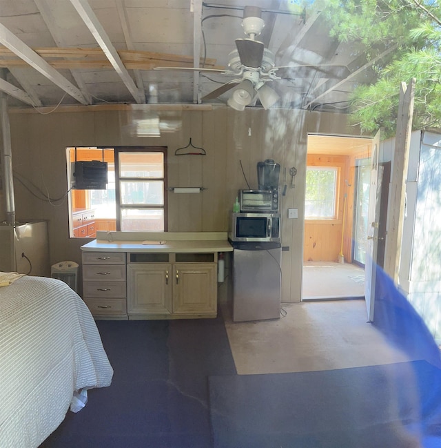 interior space featuring light countertops, concrete flooring, stainless steel microwave, fridge, and ceiling fan