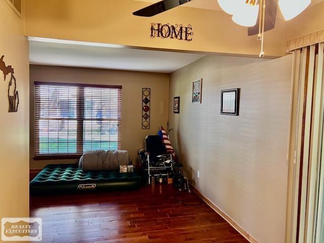 interior space with ceiling fan and dark hardwood / wood-style floors